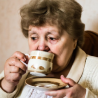 Grandmother drinking a cup of tea. She is about 60 years old. 