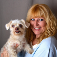 40 year old women with  long strawberry  blonde hair, blue eyes ,no wrinkles with her  small white dog that  both  her and the dog are smiling