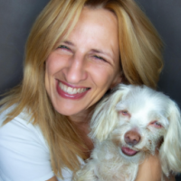 40 year old women with  long strawberry  blonde hair, blue eyes ,no wrinkles , no makeup with her  small white dog that  both  her and the dog are smiling